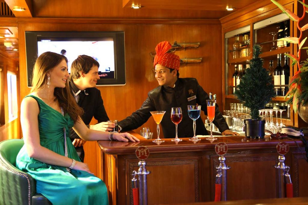 Pareja junto al camarero del bar del Maharajas Express