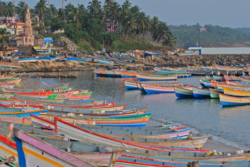 Mezquita y barcas de pescadores de colores en puerto de Vizhinjam 