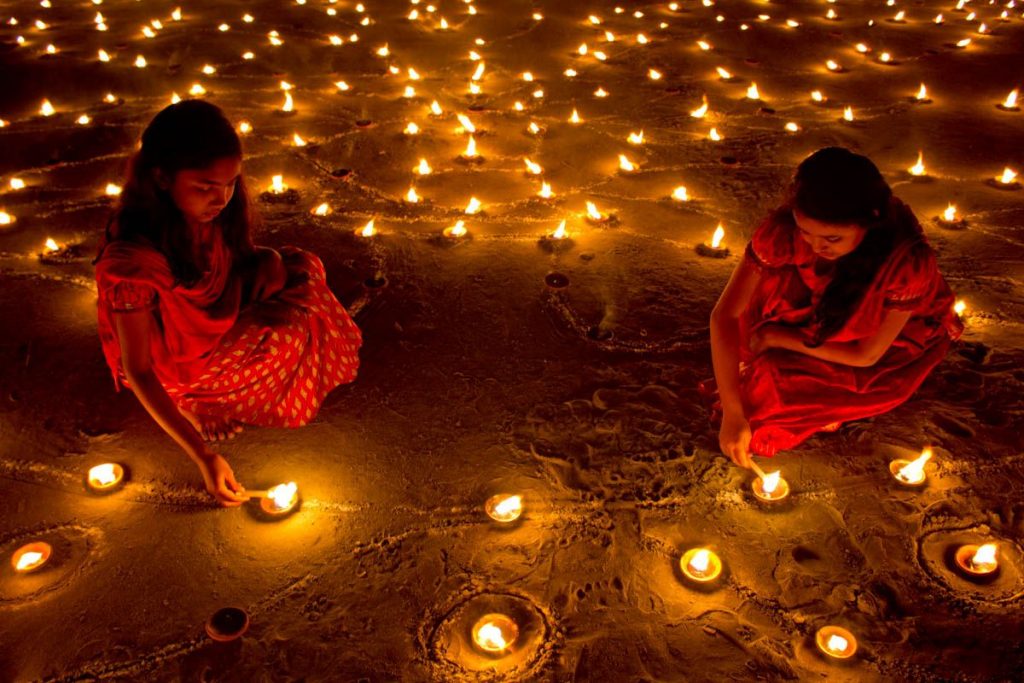 Velas y rangolis encendiéndose e n Diwali