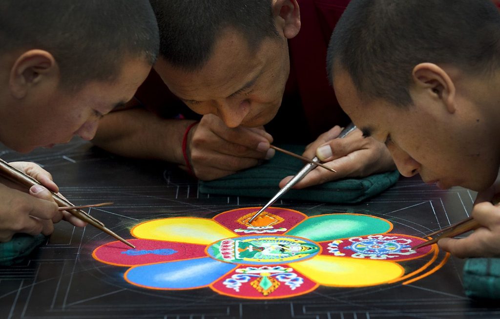 Monjes budistas pintando mandalas 