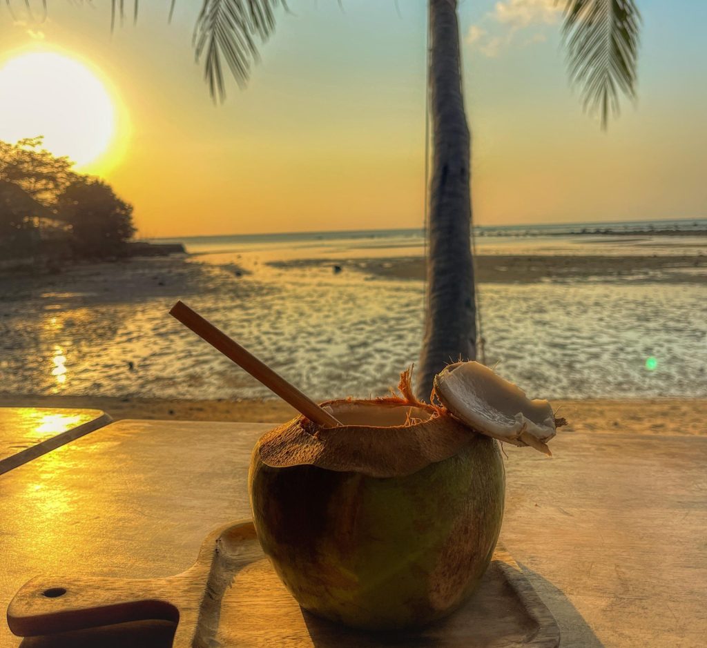 Agua de coco en la playa al atardecer