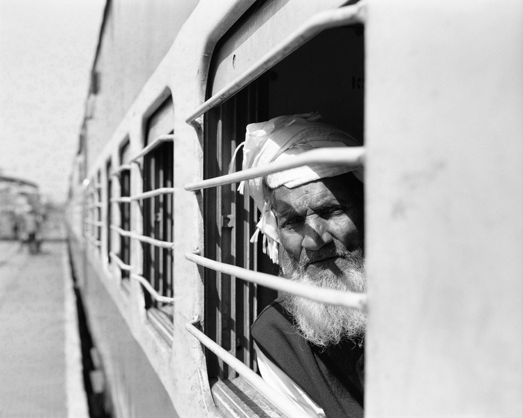 hombre indio asomado en ventana de tren postal de tren en india