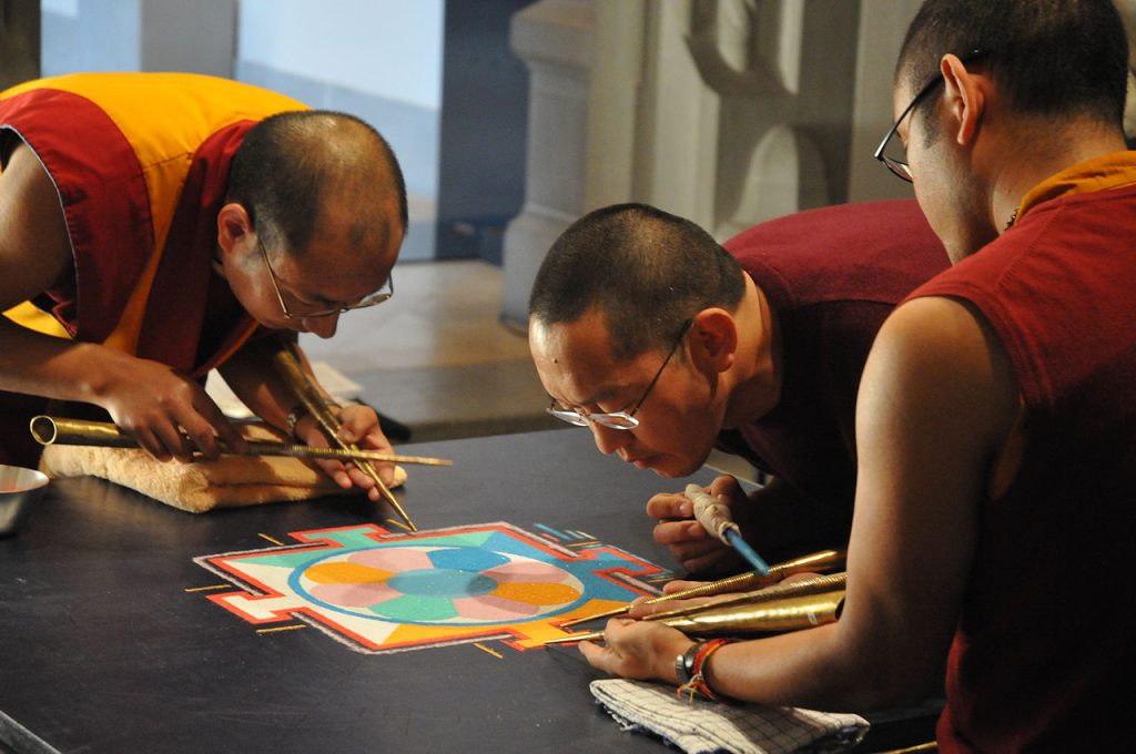 Monjes creando el centro de un mandala de arena