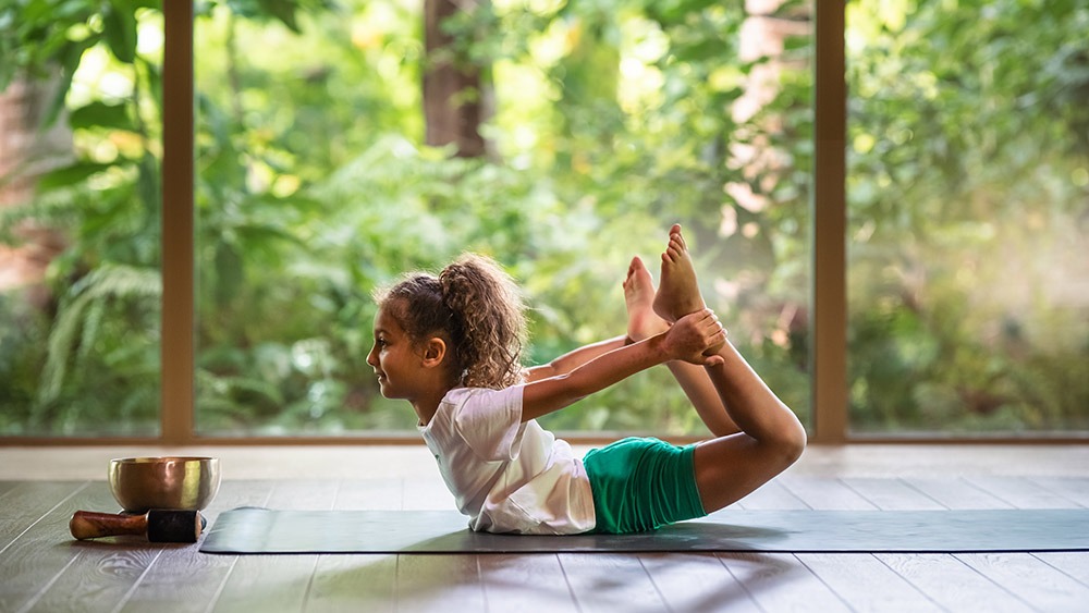 niña practicando yoga wellness en maldivas