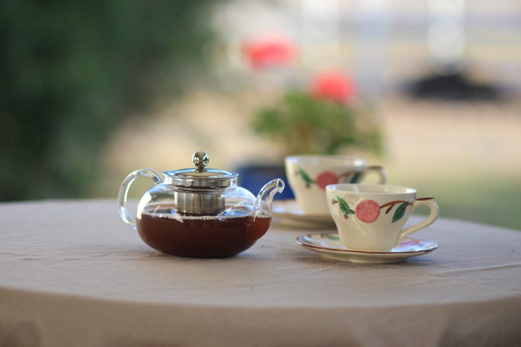 tetera con té y tazas de porcelana en una mesa